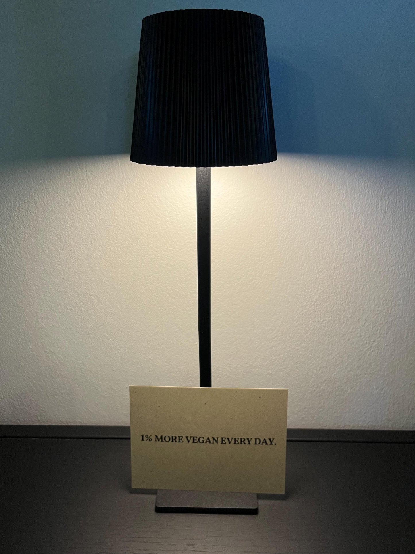 Postkarte mit Aufschrift "1% more Vegan every day" mit Lampe
